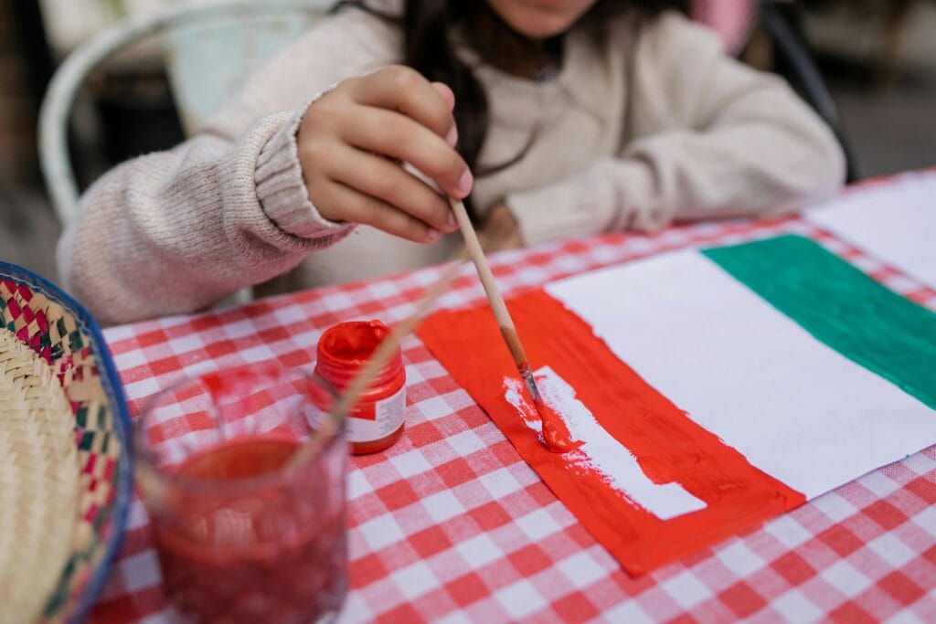 Child painting Mexican flag