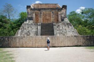 Tourist standing in front of stone temple in chichen itza